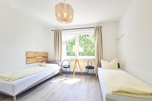 um quarto branco com 2 camas e uma janela em Gästehaus Bigge Elements em Olpe