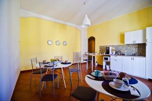 kuchnia ze stołami i krzesłami w pokoju w obiekcie B&B il Faro w mieście Salerno