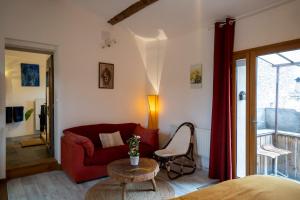 sala de estar con sofá rojo y mesa en Le nid de la Buèges en Pégairolles-de-Buèges