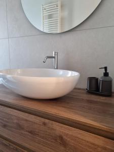 a white sink on a wooden counter in a bathroom at Massi’s House in Milan