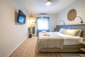 a bedroom with a bed and a tv on the wall at כפר הנופש קיבוץ גדות Kibbutz Gadot Galilean Resort in Gadot