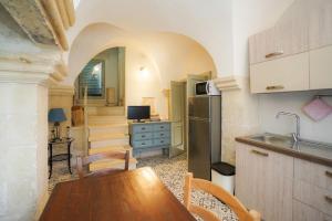 a kitchen with a table and a refrigerator in a room at Pietra Viva in Martano