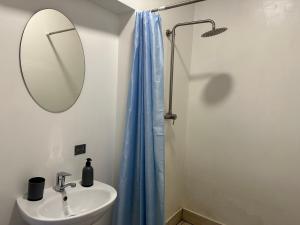 bagno con lavandino e doccia con tenda blu di Апартаменти на вул. Біла,5а a Rivne