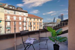 balkon z 2 krzesłami i doniczką w obiekcie AMI’s Terrace - new gem in CityLife district w Mediolanie