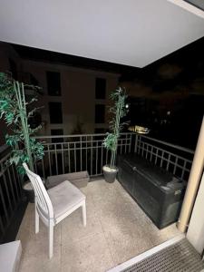 a balcony with a chair and two potted plants at Cosy Appartement in Le Blanc-Mesnil
