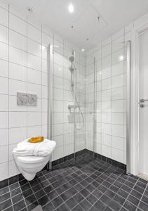 a white bathroom with a shower and a toilet at Seaside apt - 2 sunny balconies - Modern - 5 pax in Oslo
