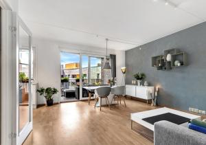 a living room with a table and a dining room at Seaside apt - 2 sunny balconies - Modern - 5 pax in Oslo