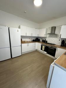 a kitchen with white appliances and white cabinets at Quirky Oasis Anfield in Liverpool
