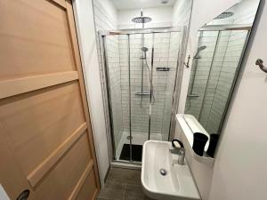 La salle de bains est pourvue d'une douche et d'un lavabo. dans l'établissement Appartement rénové face au port avec parking privé, à La Trinité-sur-Mer