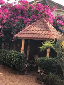 un cenador con flores rosas en una casa en Résidence Keur Fleurie Sénégal, en Rufisque