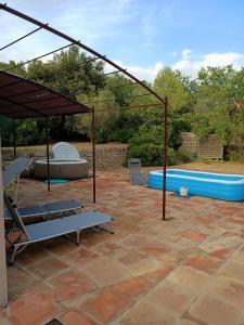 un patio con sombrilla y piscina en Charmante Petite Maison & Spa à Bulles & Grande Terrasse Plein SUD !, en Entrecasteaux