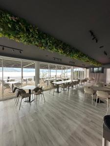 a dining room with tables and chairs and windows at Melin Residence in Orşova