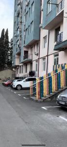 um carro branco estacionado num parque de estacionamento ao lado de um edifício em Love is... em Tbilisi