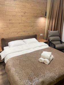 a bedroom with a bed with two towels on it at Pierre Apartments in Odesa