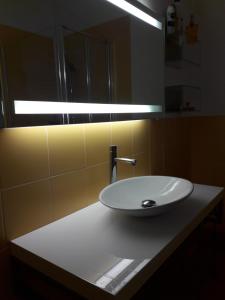 uma casa de banho com um lavatório branco e uma luz em Orange Casanova - Fibre-Optic Internet and Garden em Veneza