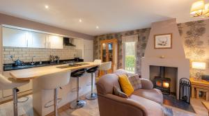 a kitchen and living room with a fireplace at Abbey Holidays Loch Ness Luxury Self Catering 2 Bedroom Cottages in Fort Augustus