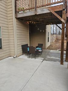 a patio with chairs and a table and a deck at Charming Oasis in Worthville