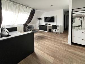 a living room with a couch and a television at DORMERO Hotel Xanten in Xanten