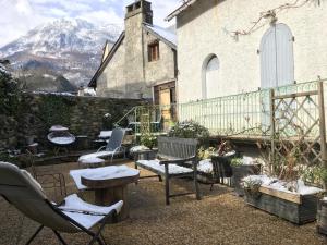 un patio con sedie e tavoli di fronte a un edificio di Les remparts a Luz-Saint-Sauveur