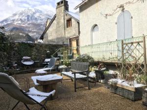 een patio met stoelen en tafels voor een gebouw bij Les remparts in Luz-Saint-Sauveur