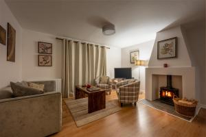 a living room with a couch and a fireplace at Abbey Holidays Loch Ness Luxury Self Catering 2 Bedroom Cottages in Fort Augustus