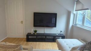 ein Wohnzimmer mit einem TV und einem weißen Sofa in der Unterkunft Alexander South Shields Coast in South Shields