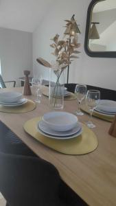 einen Holztisch mit Tellern und Weingläsern darauf in der Unterkunft Alexander South Shields Coast in South Shields