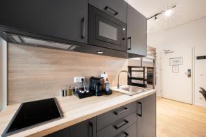 cocina con fregadero y encimera en Servus Apartments by Homaris, en Múnich