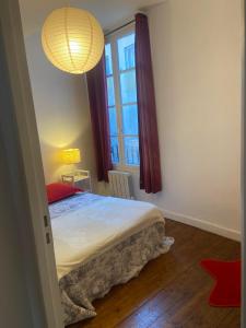 a bedroom with a bed and a large window at Béziers : charmant appartement cœur de ville, WIFI in Béziers