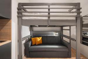 1 cama elevada con sofá en una habitación en Servus Apartments by Homaris, en Múnich
