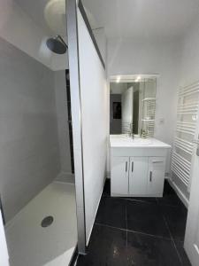 a white bathroom with a sink and a mirror at Béziers : charmant appartement cœur de ville, WIFI in Béziers