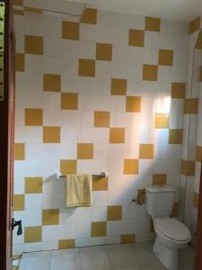 baño con aseo y pared de azulejos en Résidence Keur Fleurie Sénégal, en Rufisque