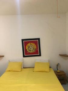 1 dormitorio con 2 camas con almohadas amarillas en Résidence Keur Fleurie Sénégal, en Rufisque