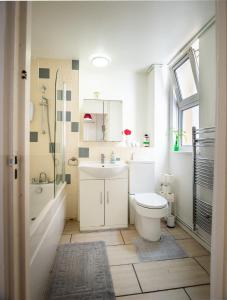 a bathroom with a toilet and a sink and a shower at NEW - Serviced Apartment - Exel & O2 & Canning Town - home away from home in London
