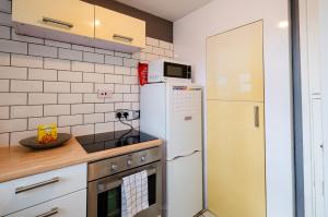 a kitchen with a white refrigerator and a microwave at NEW - Serviced Apartment - Exel & O2 & Canning Town - home away from home in London