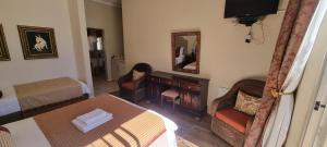 - une chambre avec un lit, une table et un miroir dans l'établissement Frankfort Guesthouse, à Frankfort