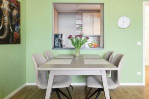 a dining room table with chairs and a vase of flowers at HomeSweetHome Wedel in Wedel +9 photos
