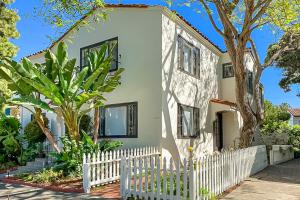 a white picket fence in front of a house at East Beach Retreats in Santa Barbara