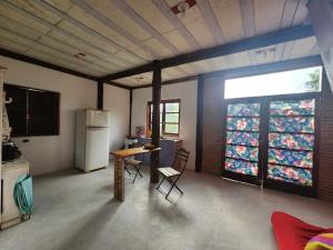 a kitchen with a refrigerator and a table and chairs at Casa da JUJU - Praia da Lagoinha - Ubatuba in Ubatuba +50 photos