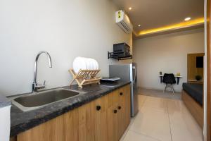 a kitchen with a sink and a refrigerator at Wandr Lepus- Sector 39, Near Medicity Medanta in Gurgaon