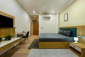 1 dormitorio con cama y escritorio en Wandr Lepus- Sector 39, Near Medicity Medanta en Gurgaon