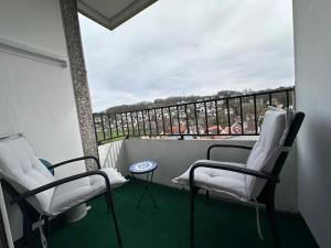 2 Stühle und ein Tisch auf einem Balkon mit Aussicht in der Unterkunft Ausblick Spessart Ferienwohnung nähe Therme und Salzgrotte in Bad Soden-Salmünster