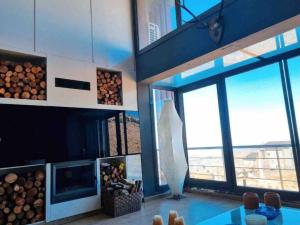 a living room with a fireplace and a large window at Modern 2BR Duplex in Afqā