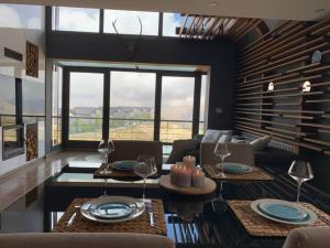 una sala de estar con sofás y mesas con copas de vino en Modern 2BR Duplex, en Afqā