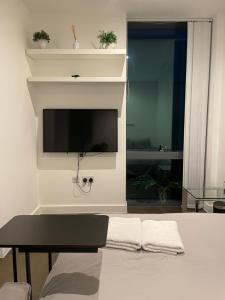 uma sala de estar com uma televisão de ecrã plano na parede em Shared Apartment in Central London em Londres