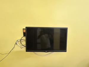 telewizor z płaskim ekranem wiszący na ścianie w obiekcie SELVAS BUDGET STAY w mieście Puducherry
