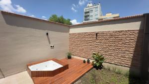 un bain à remous sur une terrasse à côté d'un bâtiment dans l'établissement Hotel Los Aceres, à Salta