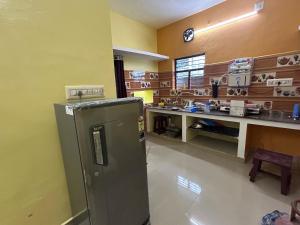 - une cuisine équipée d'un réfrigérateur au milieu d'une pièce dans l'établissement SELVAS BUDGET STAY, à Pondichéry