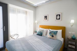 1 dormitorio con cama y ventana en Gruccio Yellow Studio - A Sunny Skiathos Gem, en Skiathos