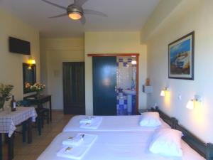 普拉坦亞斯的住宿－卡捷琳娜海濱一室公寓公寓式酒店，一间卧室配有两张床、一张桌子和吊扇。